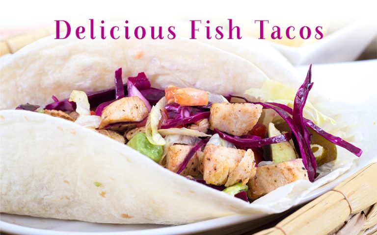 Chunks of white fish and red cabbage slaw with avocado wrapped in a flour tortilla